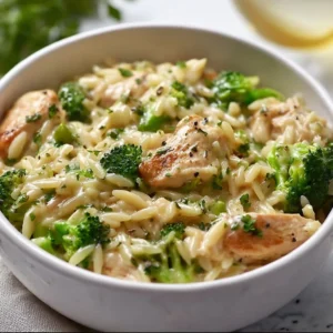 A bowl of Chicken and Broccoli Orzo featuring tender chicken and fresh broccoli in a creamy sauce.