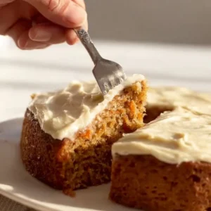Slice of easy carrot cake with cream cheese frosting on a plate