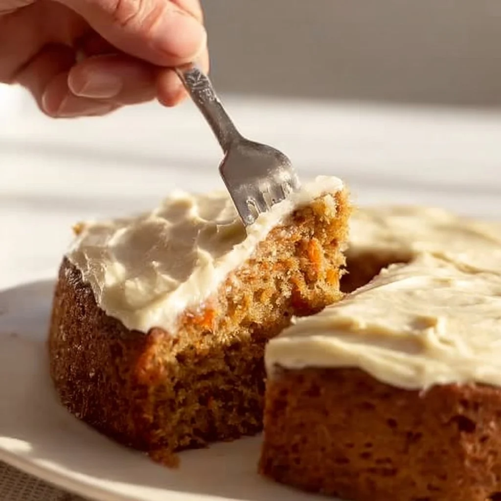 Slice of easy carrot cake with cream cheese frosting on a plate