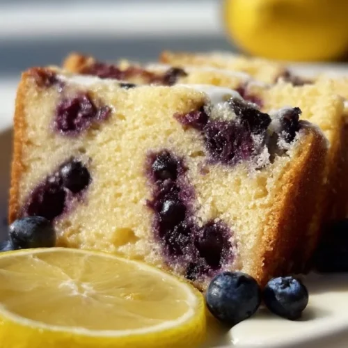 Soft and moist lemon blueberry yogurt cake served on a rustic plate.